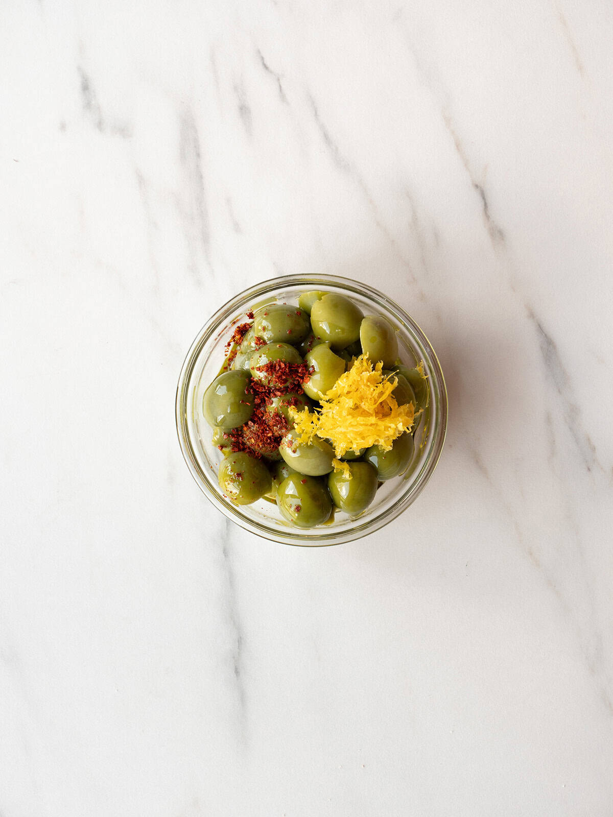 Green olives with spices and zest