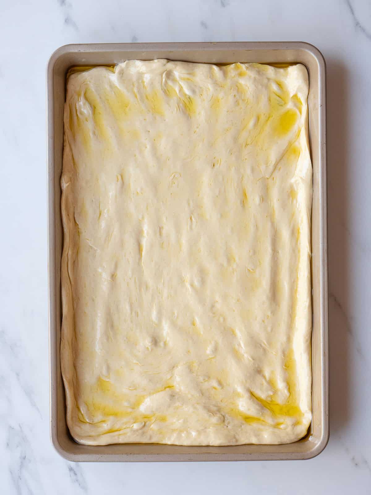 Raw pizza dough in baking pan