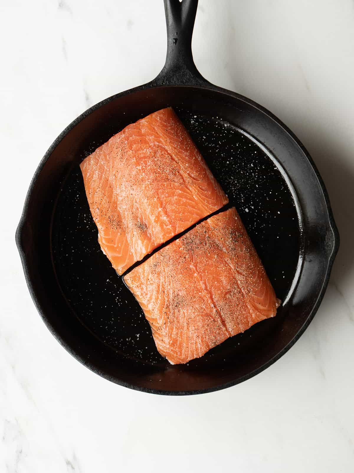 Two salmon fillets in skillet
