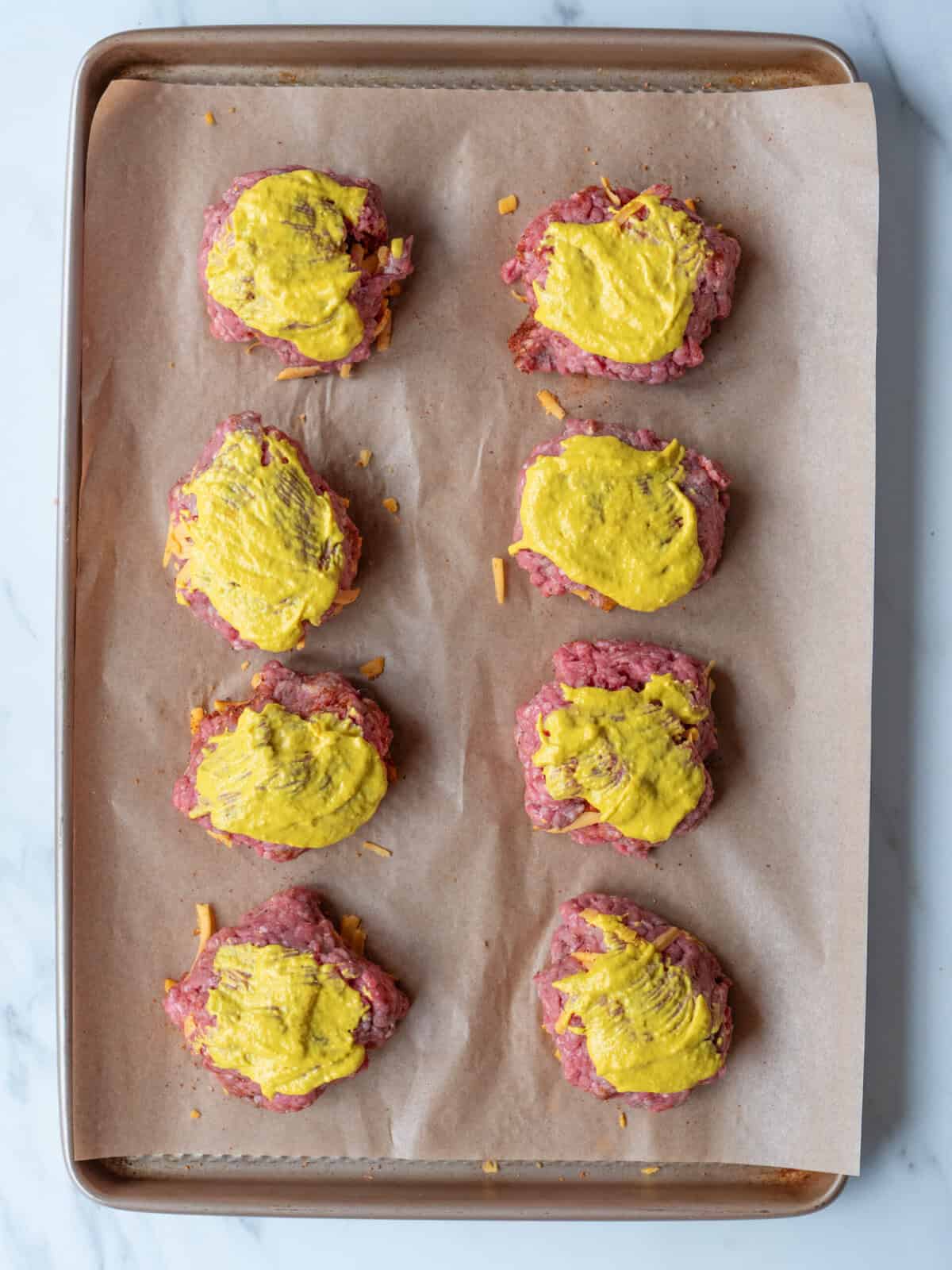 Raw patties topped with mustard