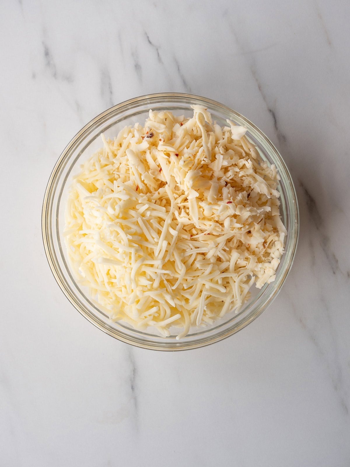 Shredded cheese in a glass bowl