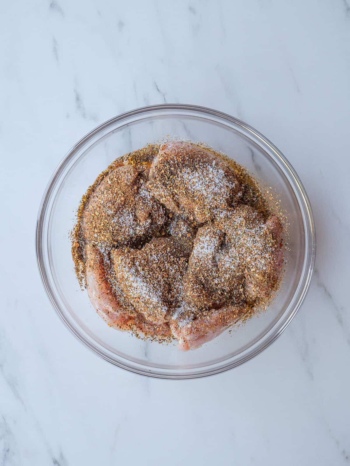Raw chicken seasoned in a bowl