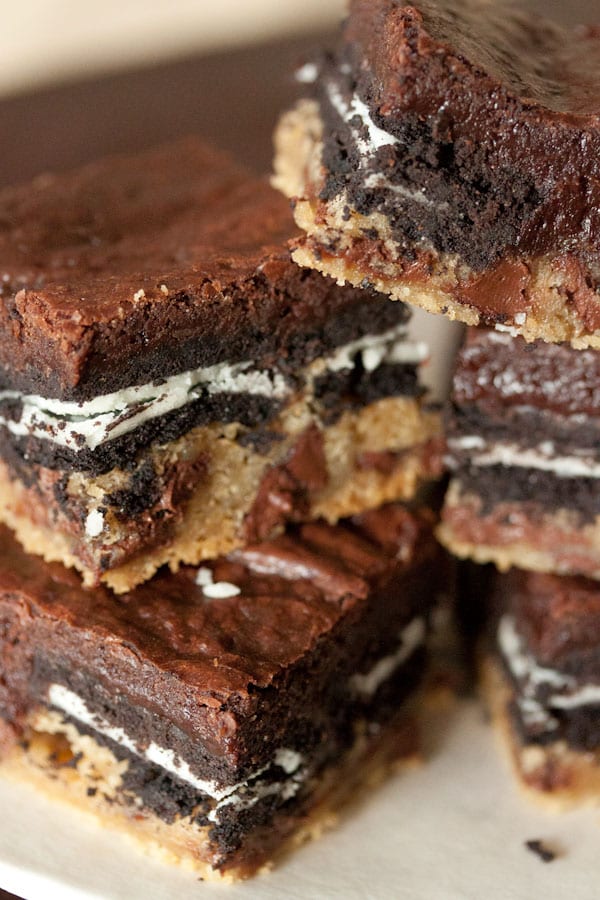 Four slutty brownies with layers of brownie, cookie dough, and oreo displayed.  